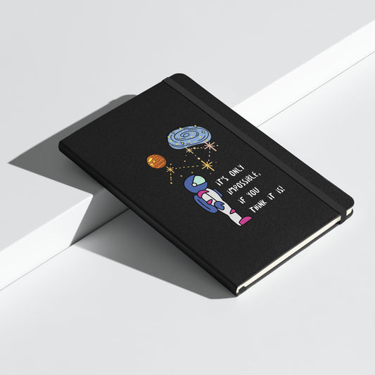 Black notebook with an astronaut illustration, planets, and the quote "It's only impossible if you think it is" on the cover.