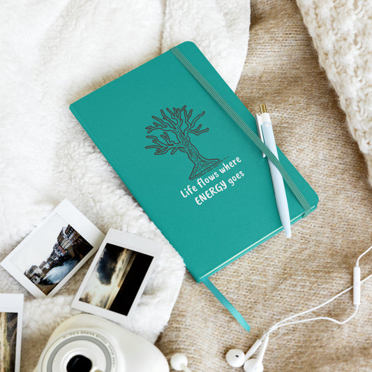 Teal notebook with a tree illustration and the quote "Life flows where energy goes."