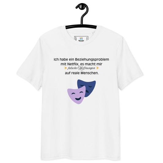Weißes T-Shirt mit Text: „Ich habe ein Beziehungsproblem mit Netflix, es macht mir falsche Hoffnungen auf reale Menschen.“ und zwei Theatermasken.