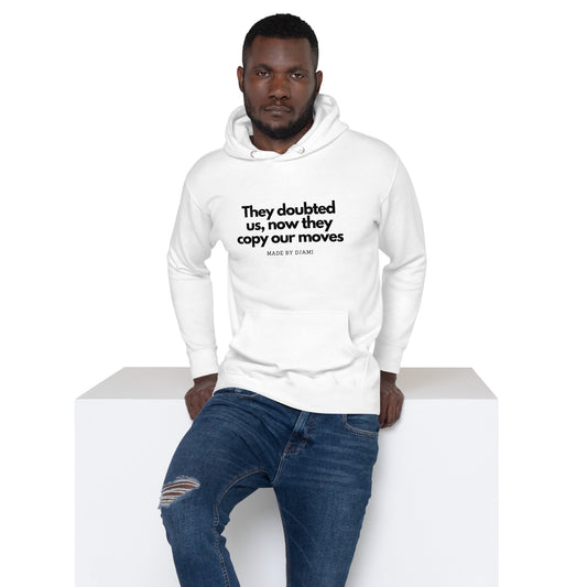 Product mockup of a White Hoodie with the text printed they doubted us, now they copy our moves